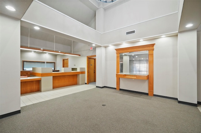 interior space featuring recessed lighting, visible vents, a towering ceiling, light carpet, and baseboards