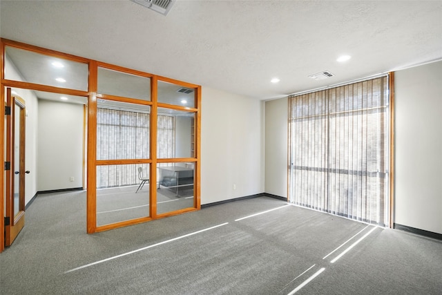 carpeted empty room featuring recessed lighting, visible vents, a textured ceiling, and baseboards