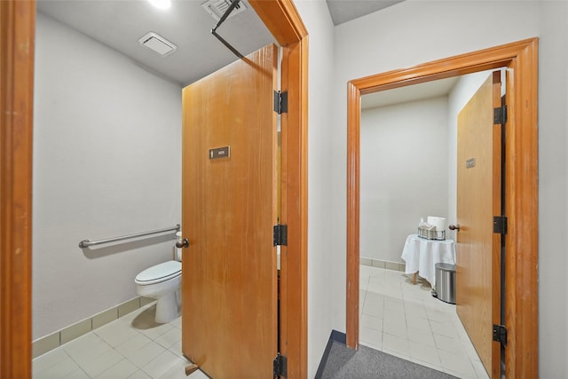 bathroom featuring baseboards, visible vents, toilet, and tile patterned floors