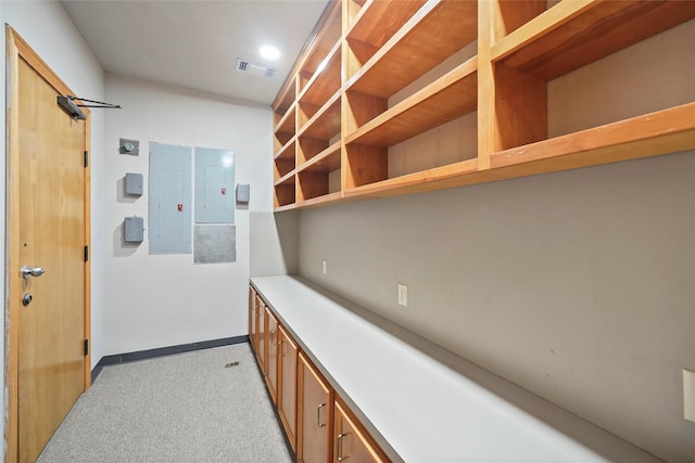 interior space featuring visible vents, baseboards, electric panel, and light colored carpet