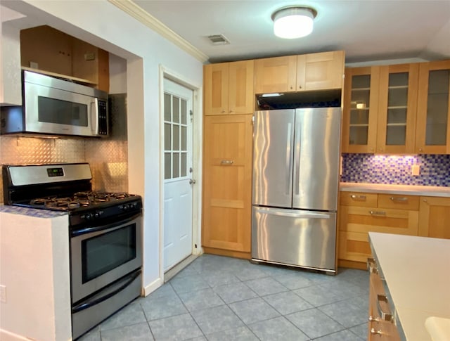 kitchen featuring backsplash, appliances with stainless steel finishes, light brown cabinetry, light tile patterned floors, and crown molding