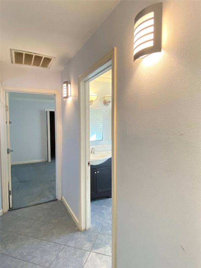 corridor with sink and light tile patterned flooring