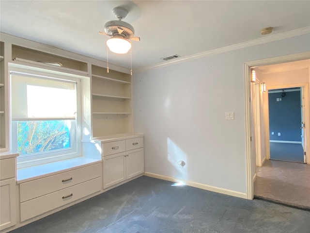 unfurnished bedroom featuring dark colored carpet, ornamental molding, and ceiling fan