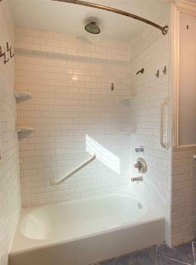 bathroom with tiled shower / bath and tile patterned flooring