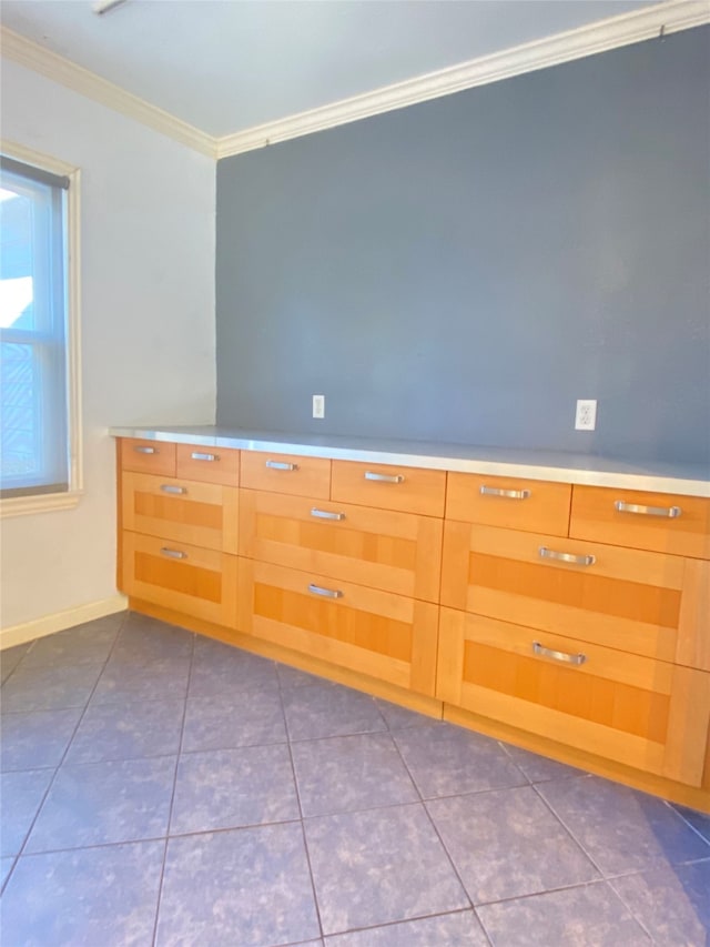 empty room featuring tile patterned floors and crown molding