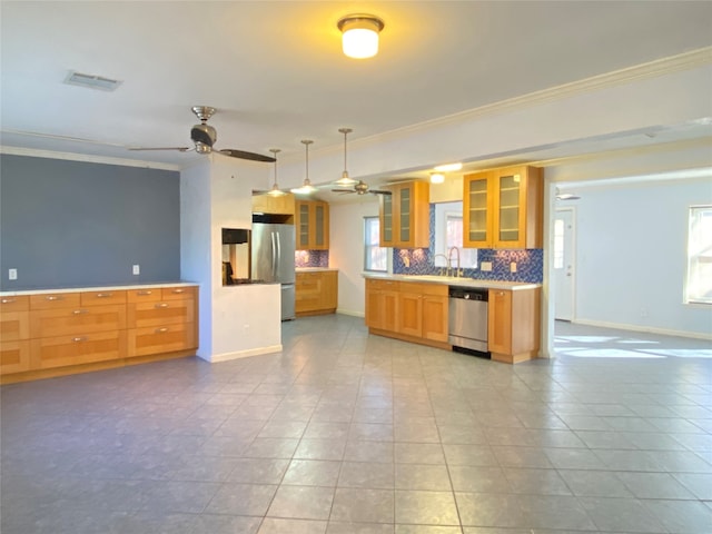 kitchen with plenty of natural light, ceiling fan, decorative backsplash, and stainless steel appliances