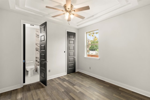 unfurnished bedroom featuring ceiling fan, a raised ceiling, and hardwood / wood-style flooring