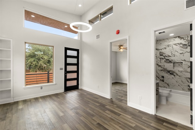 interior space featuring a towering ceiling, hardwood / wood-style floors, and ceiling fan