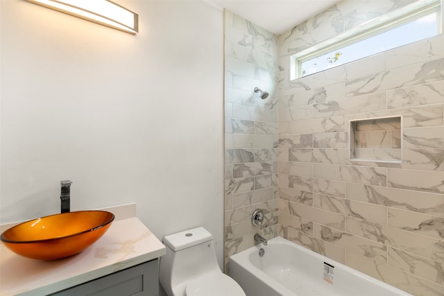 full bathroom featuring tiled shower / bath combo, toilet, and vanity