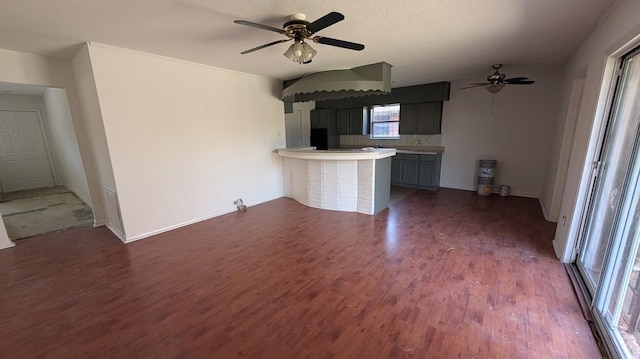 unfurnished living room with ceiling fan and dark hardwood / wood-style floors