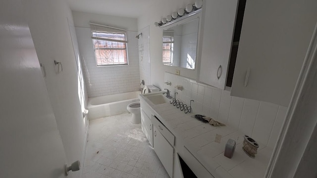 full bathroom featuring tiled shower / bath combo, vanity, and toilet