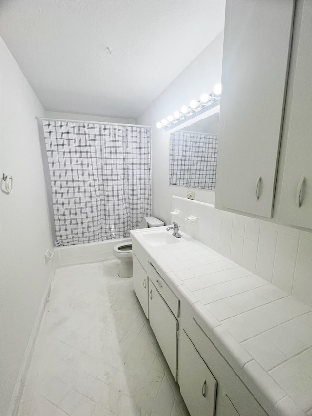 full bathroom with baseboards, vanity, and toilet