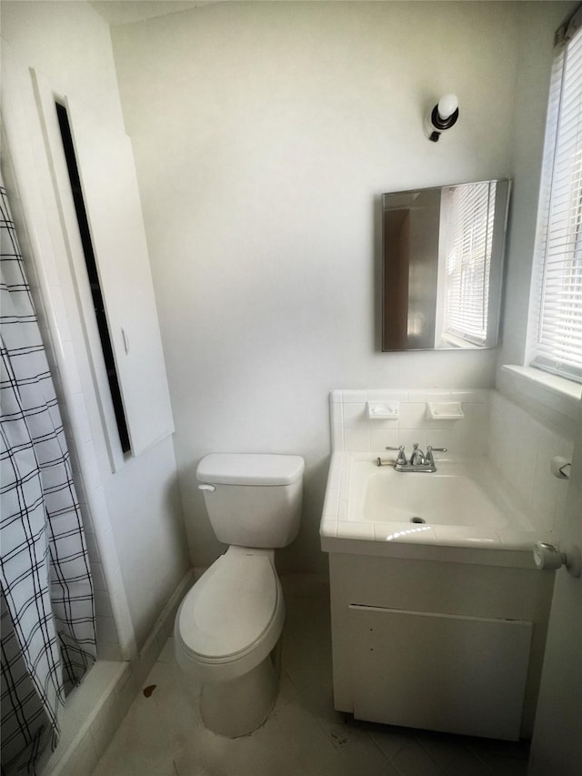 full bath featuring a shower with shower curtain, vanity, and toilet