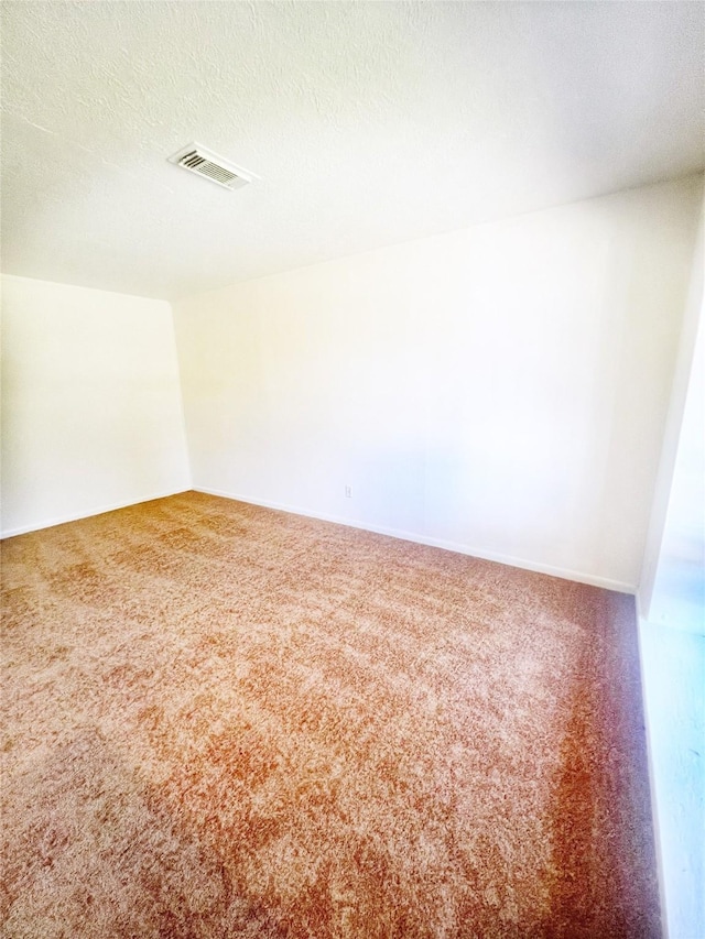 unfurnished room with baseboards, visible vents, a textured ceiling, and carpet flooring