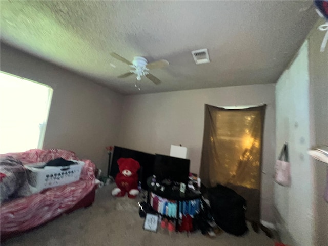 bedroom with a ceiling fan, visible vents, a textured ceiling, and carpet flooring