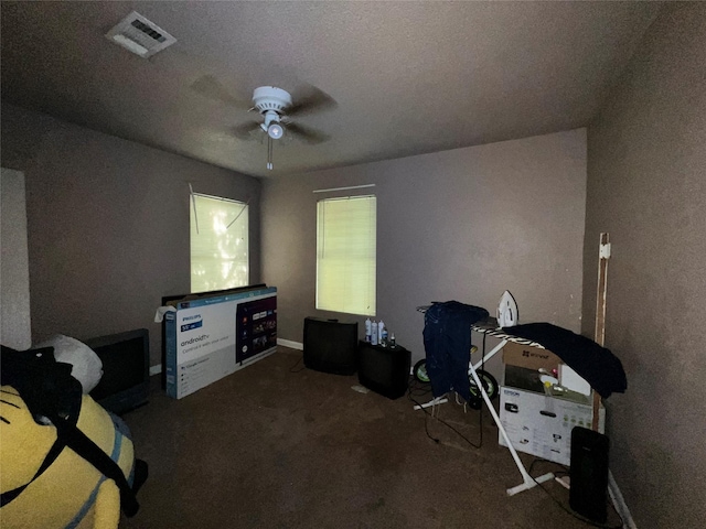 interior space with ceiling fan, visible vents, and carpet flooring