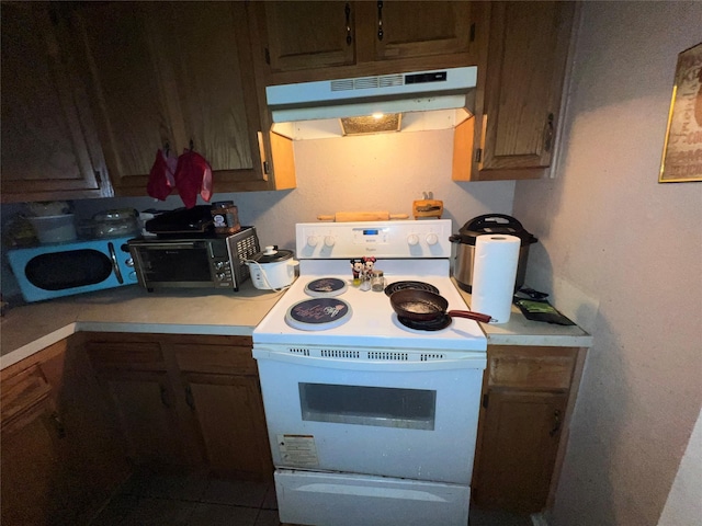 kitchen with a toaster, light countertops, under cabinet range hood, and white electric range oven