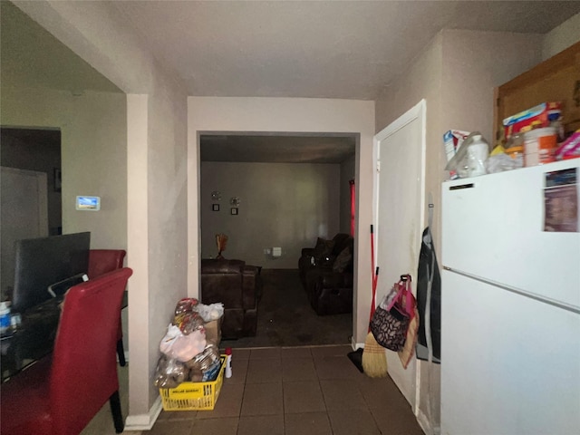 interior space featuring dark tile patterned flooring and freestanding refrigerator