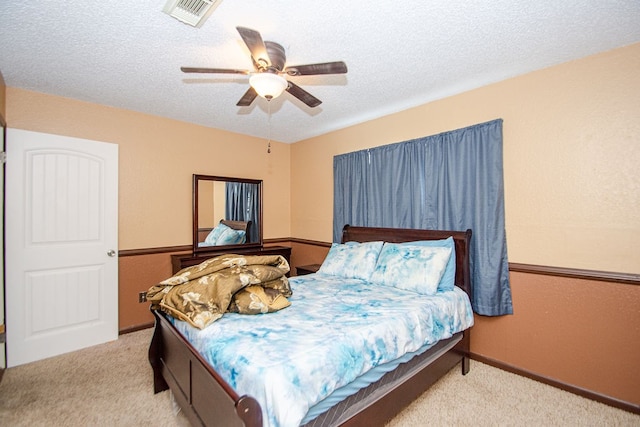 carpeted bedroom with a textured ceiling and ceiling fan