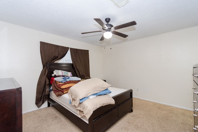 carpeted bedroom featuring ceiling fan and a textured ceiling