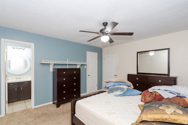 bedroom with a textured ceiling, ceiling fan, light carpet, and ensuite bathroom