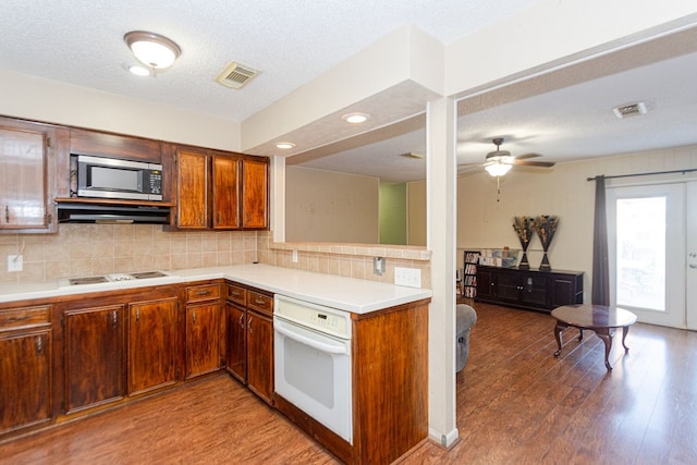 kitchen with ceiling fan, hardwood / wood-style floors, oven, and tasteful backsplash