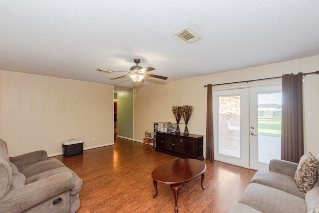 living room with ceiling fan, a textured ceiling, french doors, and wood-type flooring