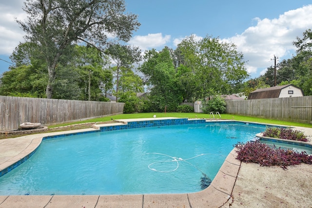 view of pool featuring a lawn and a shed