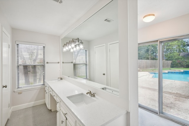 bathroom with plenty of natural light, an inviting chandelier, and vanity