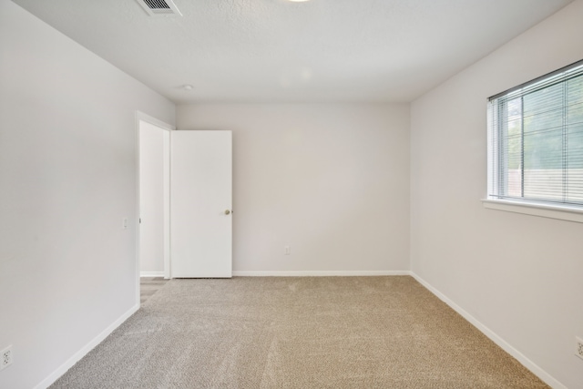 spare room featuring light colored carpet