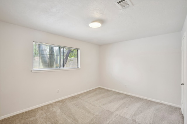 carpeted empty room with a textured ceiling