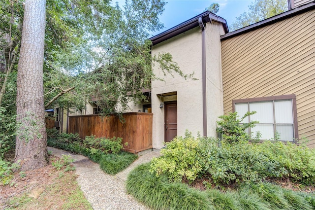 view of property exterior with fence and stucco siding