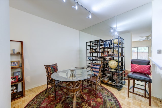 dining space with light parquet flooring, ceiling fan, and track lighting