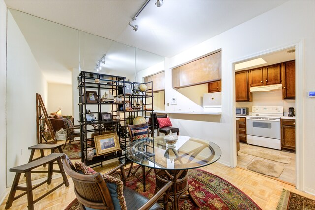 dining room with rail lighting and light parquet floors