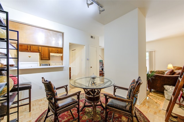 dining room featuring track lighting and light parquet floors