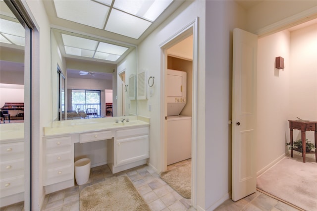 bathroom featuring vanity, ceiling fan, and stacked washer and dryer