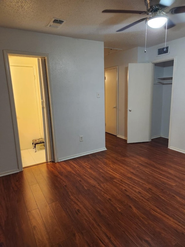 unfurnished bedroom with dark hardwood / wood-style flooring and a textured ceiling