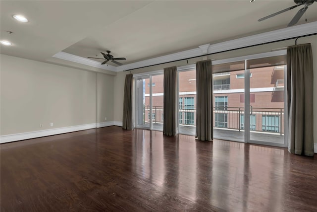 unfurnished room featuring ceiling fan, a raised ceiling, and dark wood-type flooring