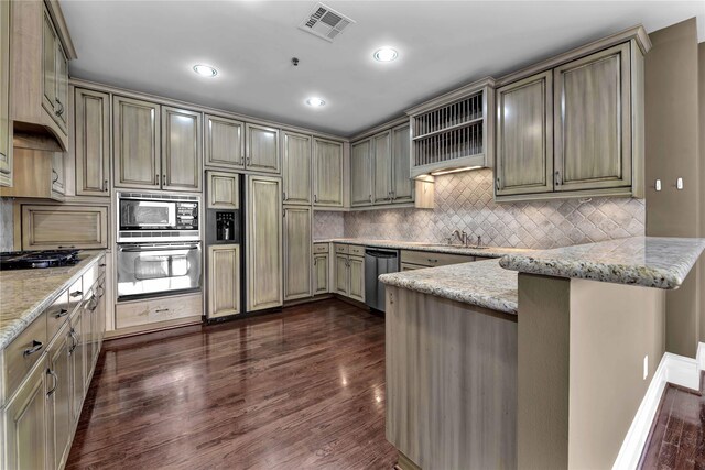 kitchen featuring light stone countertops, built in appliances, kitchen peninsula, and dark hardwood / wood-style flooring