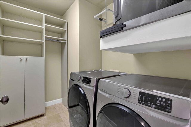 laundry area featuring independent washer and dryer and light tile patterned floors