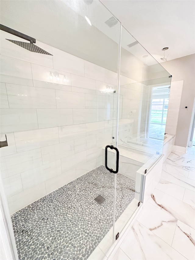 bathroom with a shower with door and tile patterned floors