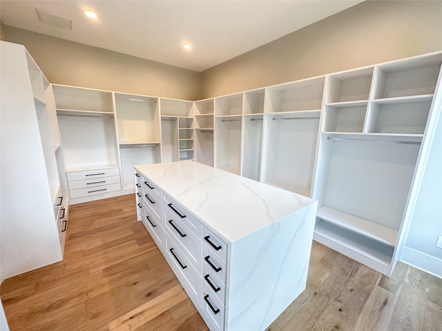 walk in closet with light hardwood / wood-style floors