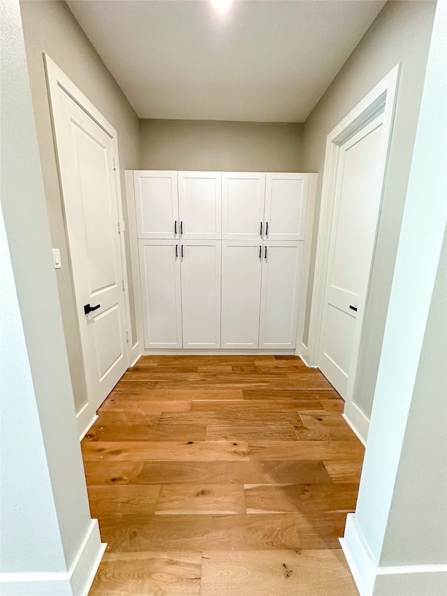 hallway with light hardwood / wood-style floors