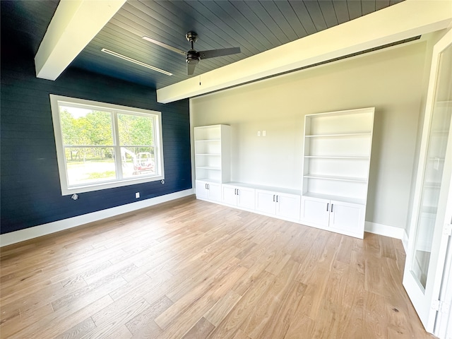 unfurnished bedroom featuring ceiling fan, light wood-type flooring, beam ceiling, a closet, and wooden ceiling