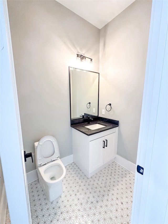 bathroom featuring toilet, tile patterned flooring, and vanity