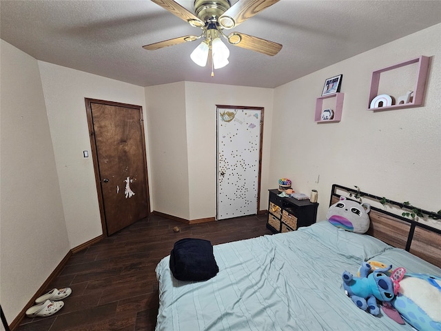 bedroom with a textured ceiling, ceiling fan, and dark hardwood / wood-style floors