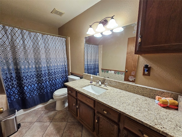 bathroom featuring tile patterned flooring, toilet, a textured ceiling, and vanity