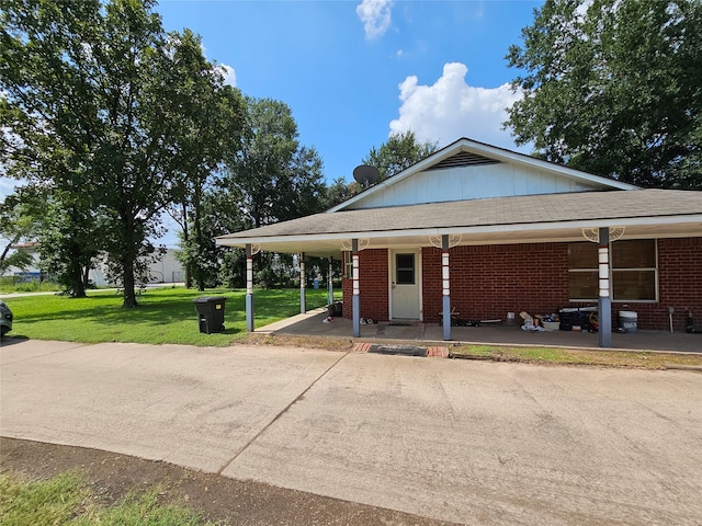 view of front of property featuring a front lawn and a carport