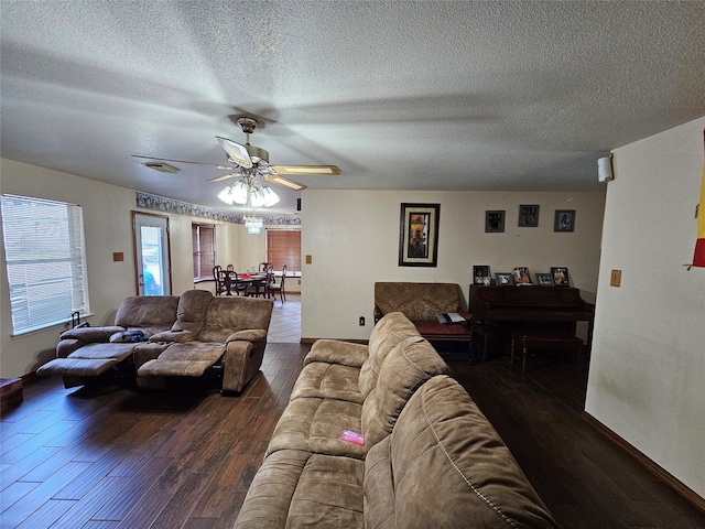 living room featuring ceiling fan, a textured ceiling, and dark hardwood / wood-style flooring