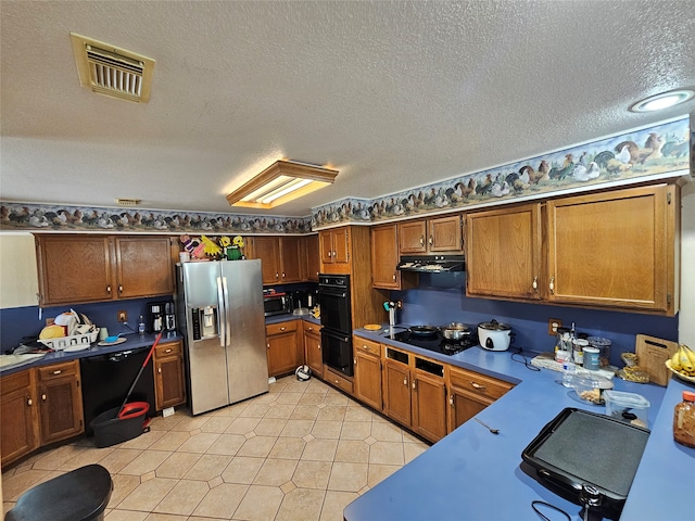 kitchen featuring light tile patterned floors, a textured ceiling, and black appliances